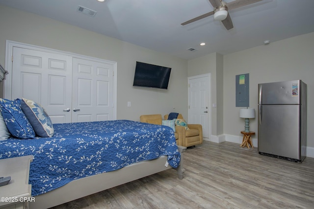 112 Riviera Dr, Panama City Beach, FL 32413 - bedroom with freestanding refrigerator, electric panel, wood finished floors, baseboards, and a closet