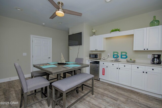 112 Riviera Dr, Panama City Beach, FL 32413 - kitchen featuring stainless steel microwave, light wood finished floors, fridge, a ceiling fan, and white cabinetry