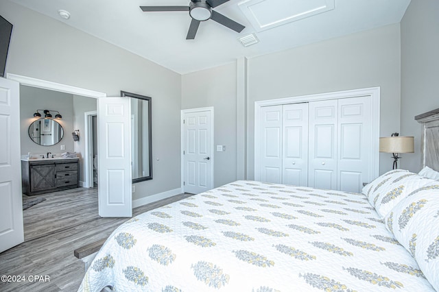 bedroom featuring connected bathroom, sink, ceiling fan, a closet, and hardwood / wood-style flooring