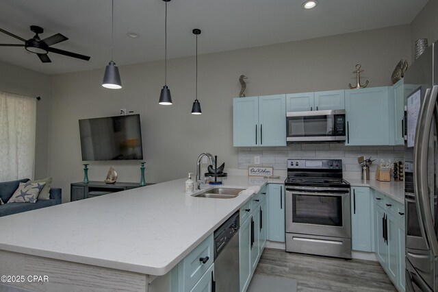 112 Riviera Dr, Panama City Beach, FL 32413 - kitchen featuring appliances with stainless steel finishes, a sink, a peninsula, open floor plan, and light wood-type flooring