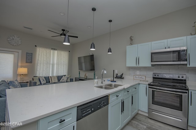 112 Riviera Dr, Panama City Beach, FL 32413 - kitchen with stainless steel appliances, a sink, open floor plan, a peninsula, and light countertops