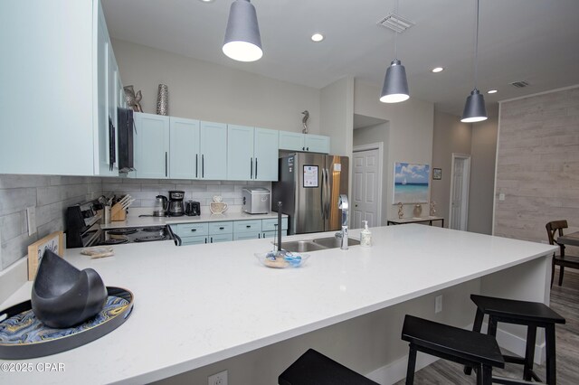 112 Riviera Dr, Panama City Beach, FL 32413 - kitchen with freestanding refrigerator, a sink, light countertops, a peninsula, and a breakfast bar area