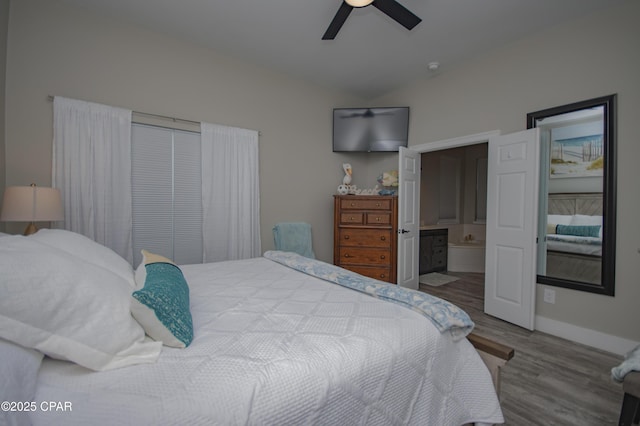112 Riviera Dr, Panama City Beach, FL 32413 - bedroom featuring wood finished floors, connected bathroom, baseboards, vaulted ceiling, and ceiling fan