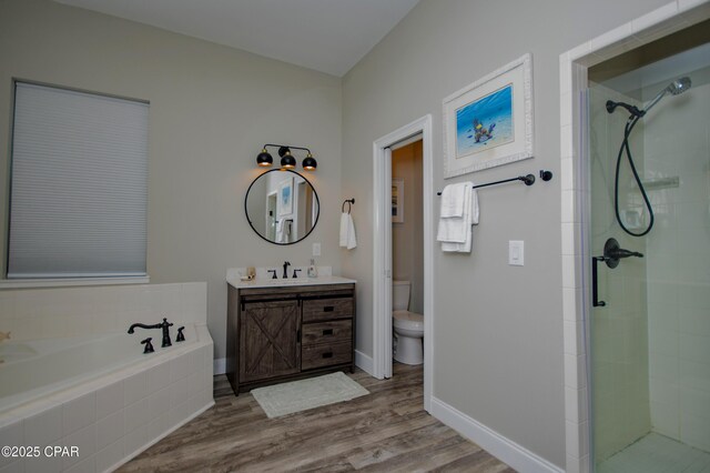112 Riviera Dr, Panama City Beach, FL 32413 - bathroom featuring toilet, a stall shower, vanity, a bath, and wood finished floors