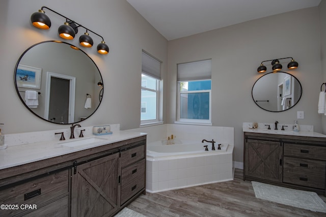 112 Riviera Dr, Panama City Beach, FL 32413 - full bathroom featuring wood finished floors, two vanities, and a garden tub