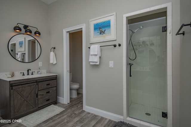 112 Riviera Dr, Panama City Beach, FL 32413 - bathroom with a stall shower, vanity, wood finished floors, and toilet
