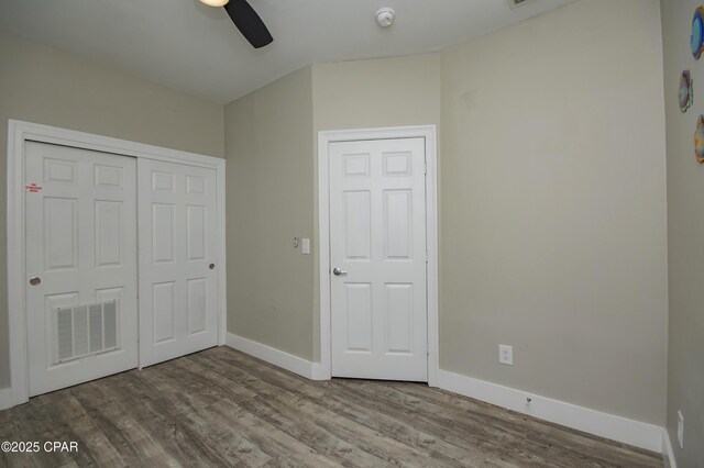 112 Riviera Dr, Panama City Beach, FL 32413 - unfurnished bedroom with wood finished floors, baseboards, a closet, and a ceiling fan