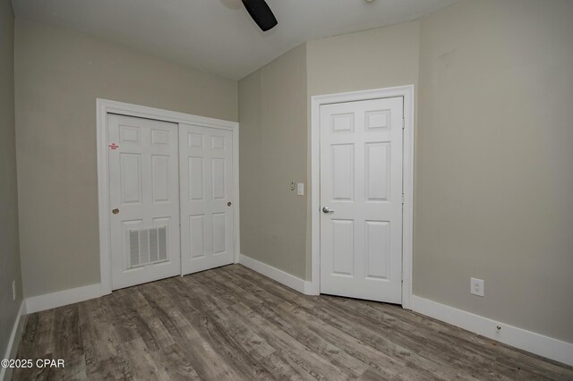 112 Riviera Dr, Panama City Beach, FL 32413 - unfurnished bedroom with wood finished floors, baseboards, a closet, and a ceiling fan