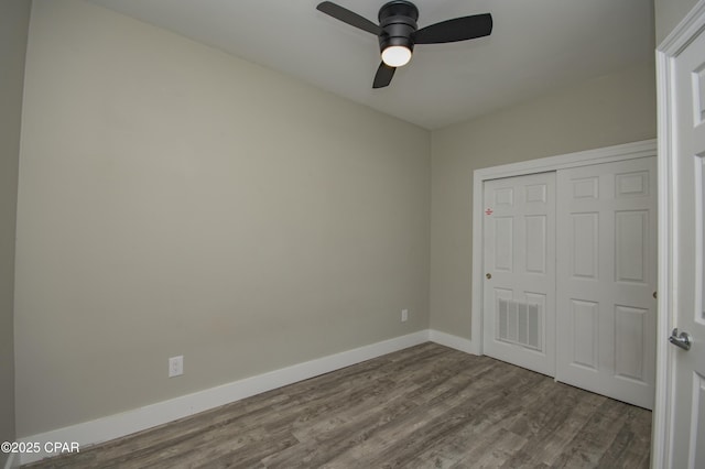 112 Riviera Dr, Panama City Beach, FL 32413 - unfurnished bedroom featuring dark wood-style flooring, baseboards, a closet, and a ceiling fan