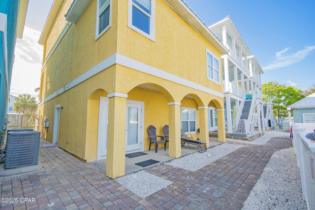 112 Riviera Dr, Panama City Beach, FL 32413 - view of building exterior featuring central AC and stairway