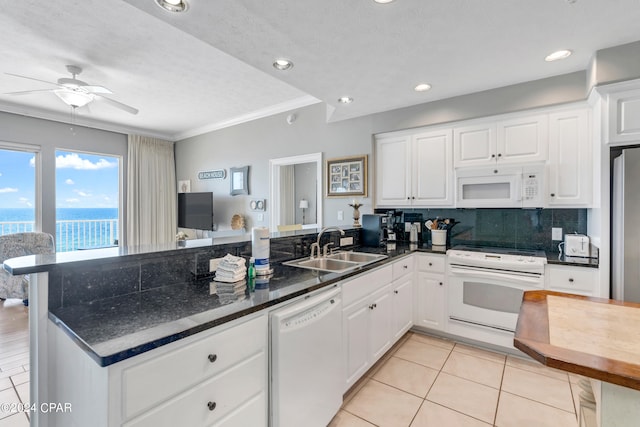 kitchen with ceiling fan, kitchen peninsula, ornamental molding, white appliances, and white cabinetry