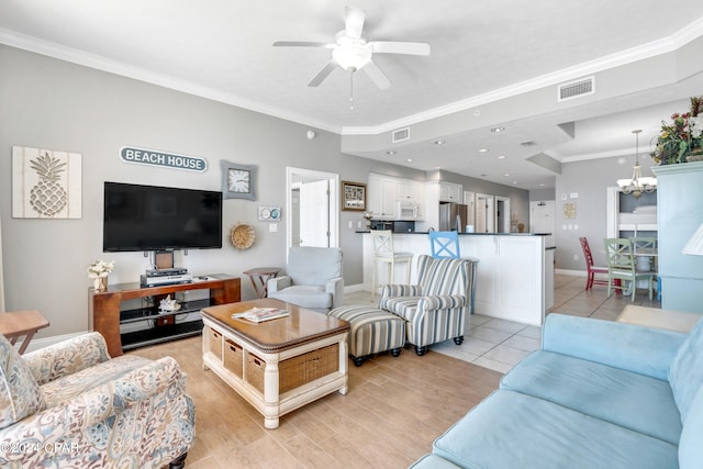 living room featuring light tile patterned floors, ceiling fan with notable chandelier, and ornamental molding