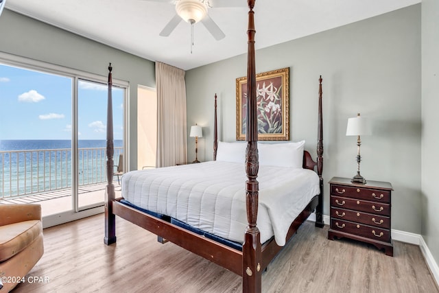 bedroom featuring light wood-type flooring, access to outside, a water view, and ceiling fan