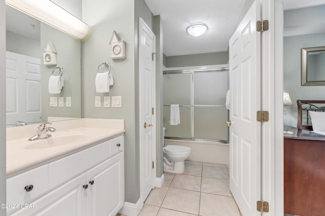 full bathroom featuring vanity, tile patterned floors, toilet, and bath / shower combo with glass door