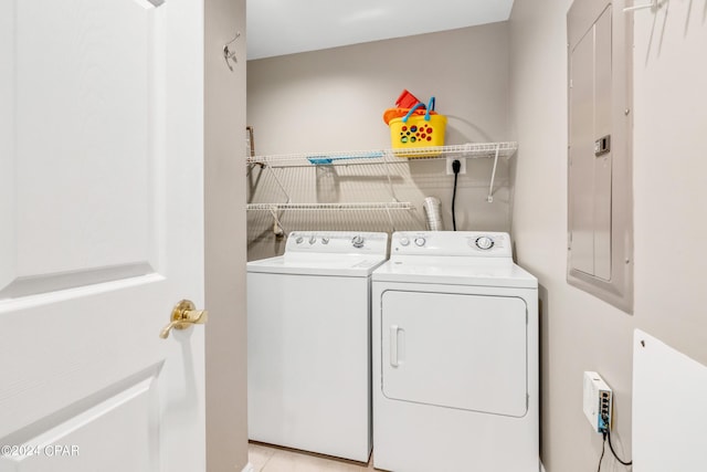 laundry area with electric panel, separate washer and dryer, and laundry area