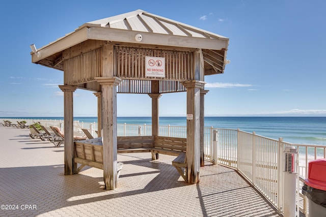 surrounding community with a gazebo, a beach view, and a water view