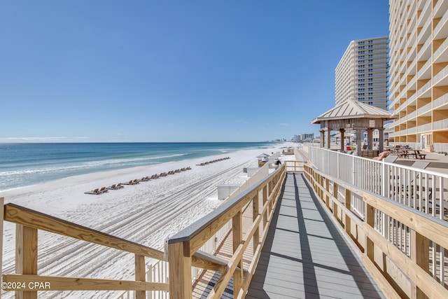 view of home's community featuring a water view and a beach view