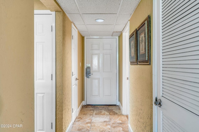entryway featuring recessed lighting, a drop ceiling, and baseboards