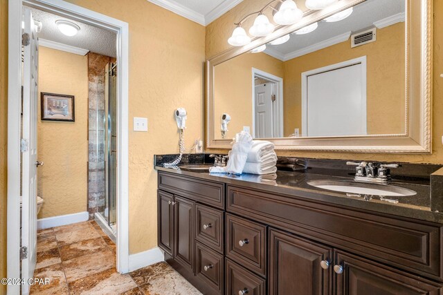 bathroom featuring toilet, ornamental molding, vanity, a textured ceiling, and a shower with shower door