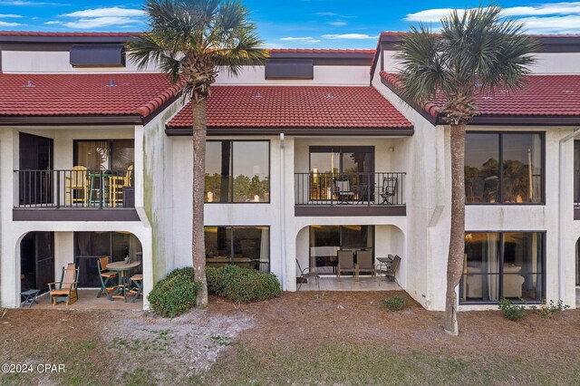 back of house featuring a balcony and a patio