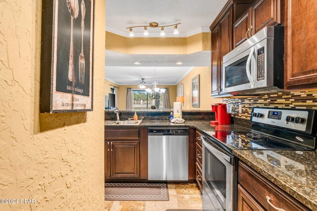 kitchen with crown molding, stainless steel appliances, sink, tasteful backsplash, and a textured ceiling