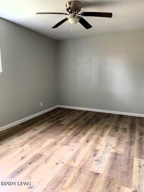 empty room with wood-type flooring and ceiling fan