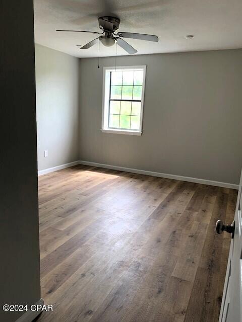 empty room featuring ceiling fan and hardwood / wood-style floors