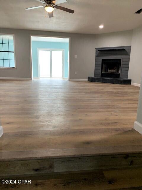 unfurnished living room featuring ceiling fan and light hardwood / wood-style flooring