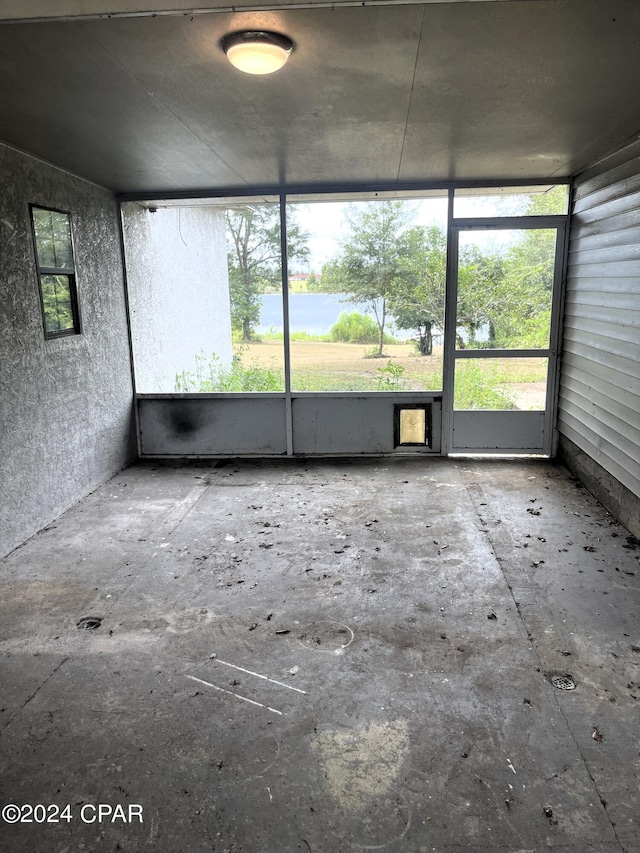 unfurnished sunroom featuring a water view