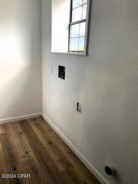 clothes washing area featuring hardwood / wood-style flooring and hookup for a washing machine