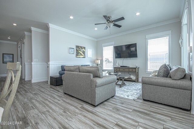 living room with ceiling fan, ornamental molding, light hardwood / wood-style floors, and a wealth of natural light