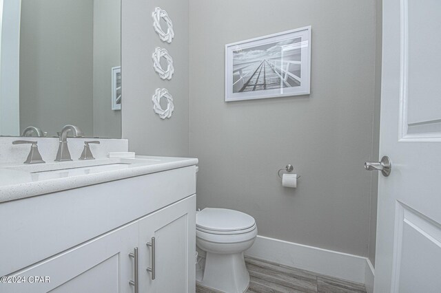 bathroom with vanity, toilet, and hardwood / wood-style flooring