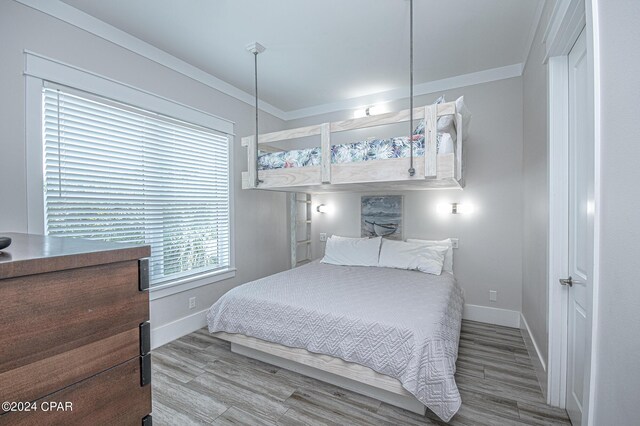 bedroom with crown molding and hardwood / wood-style floors