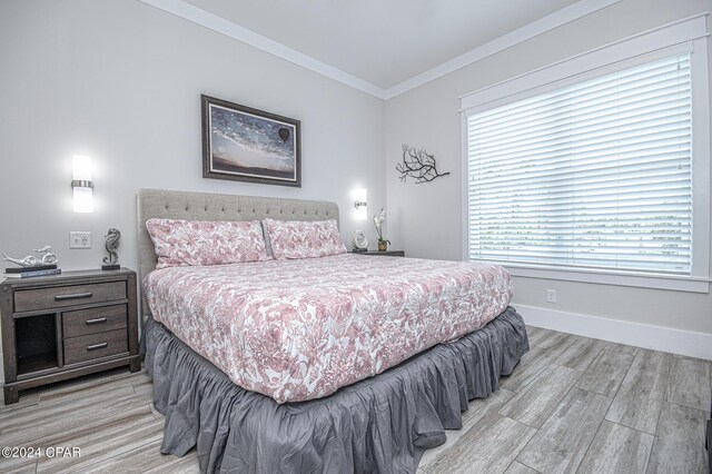 bedroom featuring ornamental molding and light hardwood / wood-style floors