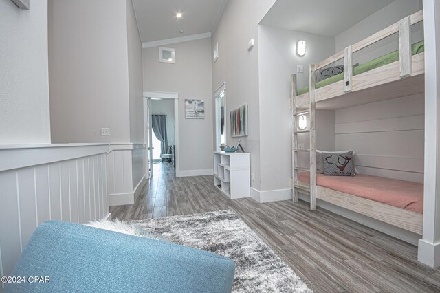 hallway featuring a high ceiling, hardwood / wood-style flooring, and crown molding