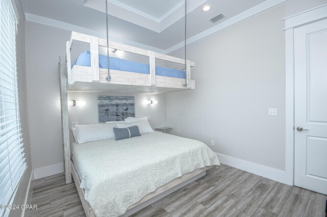 bedroom with hardwood / wood-style flooring and ornamental molding