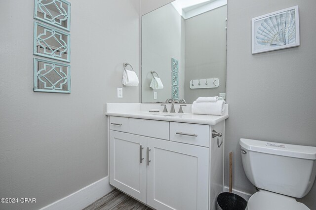 bathroom with vanity, toilet, and hardwood / wood-style flooring