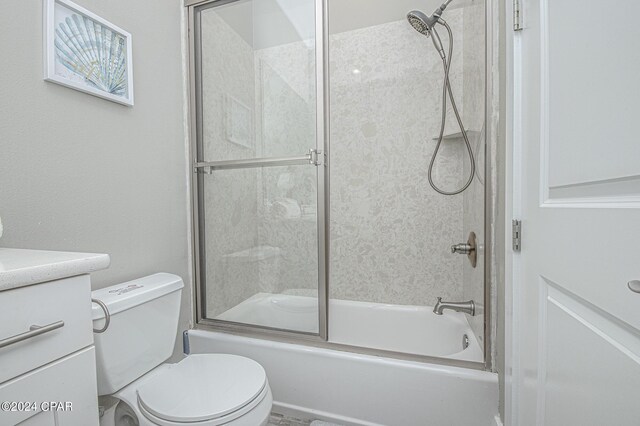 full bathroom featuring enclosed tub / shower combo, vanity, and toilet