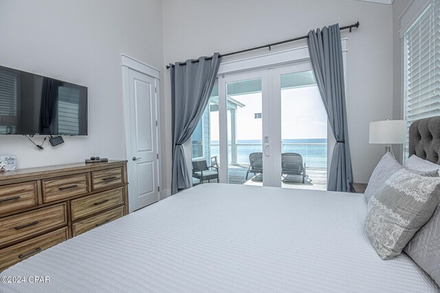 bedroom featuring a water view, access to exterior, and french doors