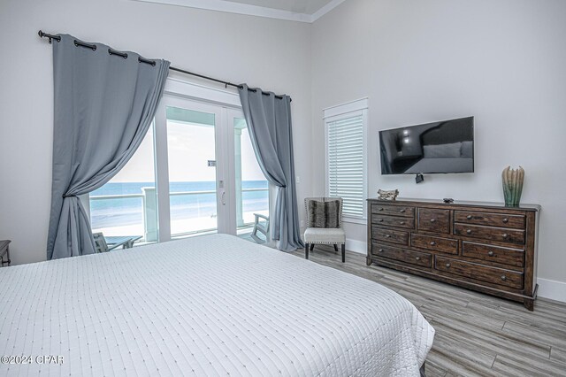 bedroom with access to outside, light hardwood / wood-style flooring, french doors, and ornamental molding