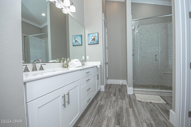 bathroom with vanity, crown molding, hardwood / wood-style floors, and an enclosed shower