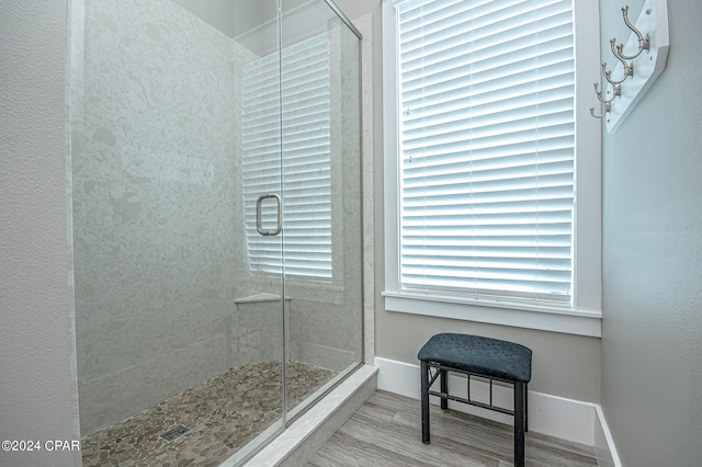 bathroom with wood-type flooring and an enclosed shower