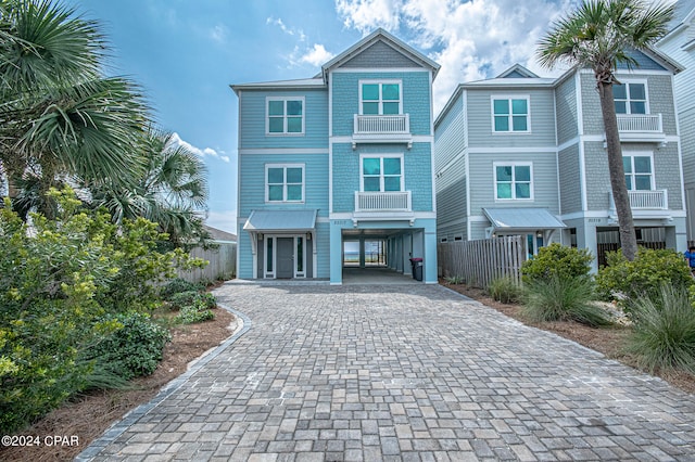 coastal inspired home featuring a balcony and a carport