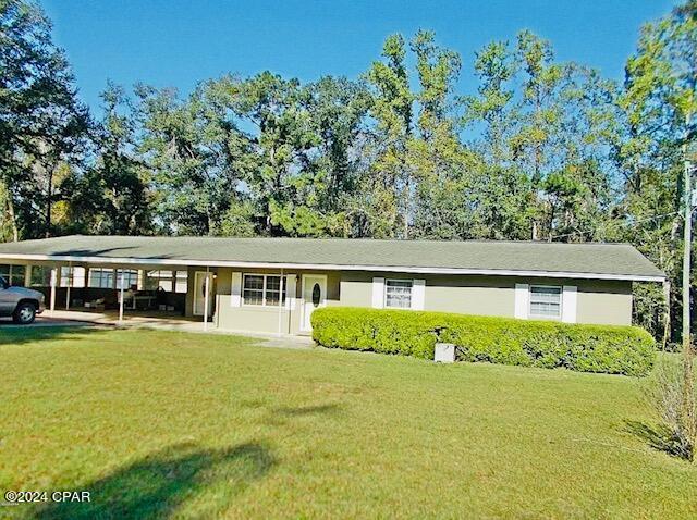 ranch-style home featuring a front yard and a carport