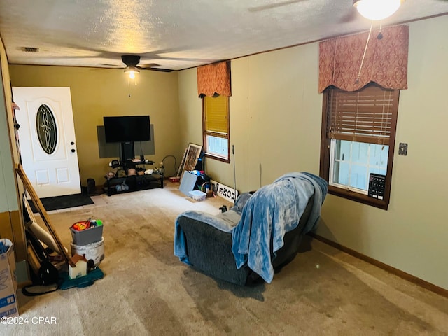 living room with carpet flooring, a textured ceiling, and ceiling fan