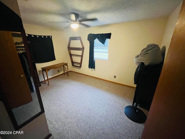 bedroom with a textured ceiling, light colored carpet, and ceiling fan