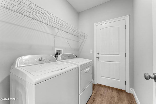 washroom with light hardwood / wood-style floors and independent washer and dryer