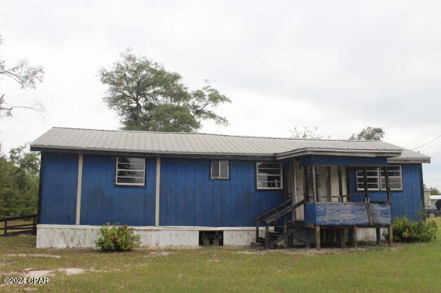 rear view of property with a lawn