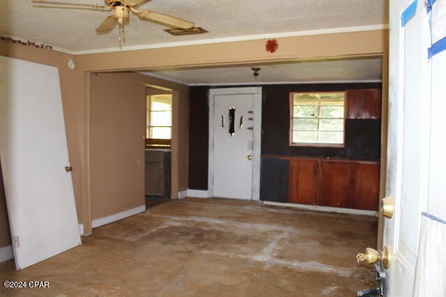 interior space with a textured ceiling, ceiling fan, and plenty of natural light