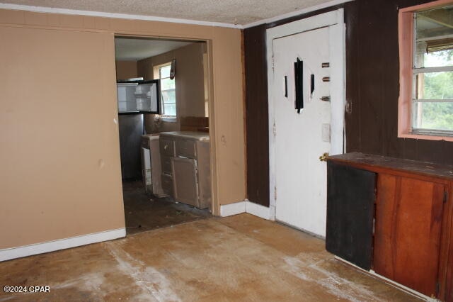 interior space featuring a textured ceiling and crown molding